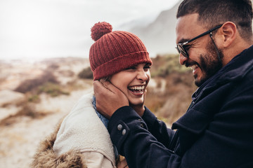 Wall Mural - Smiling couple enjoying a winter day at the beach