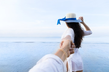 Wall Mural - couple on beach summer vacation, beautiful young girl hold male hand people looking sea ocean holida