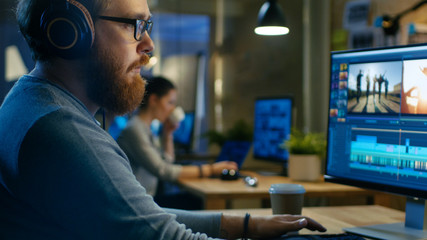Poster - Male Videographer Edits and Cuts Footage and Sound on His Personal Computer, Puts on His Monitors/ Headphones. His Office is Modern and Creative Loft Studio.