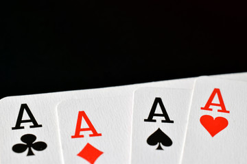 Poster - Poker hand four aces close up. Playing cards on black surface with room for text.