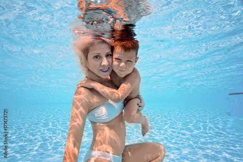 Plakat Szczęśliwa młoda matka przytulić jej syna podwodne, pływać i nurkować, udar mózgu z zabawy w basenie. Aktywny zdrowy styl życia, aktywność sportów wodnych i lekcje z rodzicami na letnie rodzinne wakacje z dzieckiem.