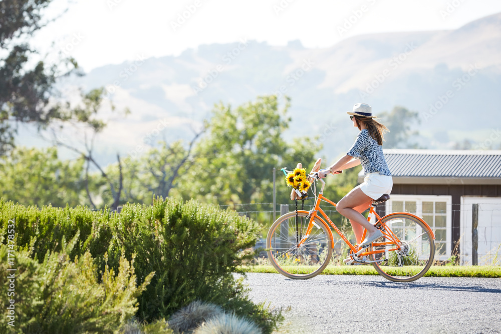 Stylish woman riding a bike in nature Stock Photo | Adobe Stock