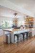 © Rob and Julia Campbell/Stocksy - Bright modern kitchen with wood bar and open shelving