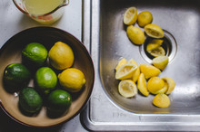 Bowl Of Citrus Fruit Beside Sink Of Squeezed Lemons