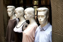 Four Mannequins Displayed On The Outside Window Sill Of A Clothes Boutique