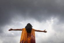 A Young Woman Stretched Arm And Monsoon Cloud At Backdrop