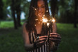 © Mauro Grigollo Photographer/Stocksy - Woman holding sparkle sticks