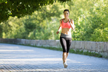 Young Smiling Sporty Woman Running In Park In The Morning. Fitness Girl Jogging In Park