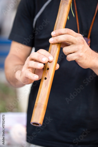 Plakat mężczyzna gra na drewnianej fajce