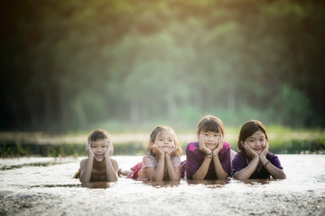 Wall Mural - asian child lay on water on rural scene