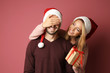 © Africa Studio - Young woman giving her boyfriend Christmas present, on color background
