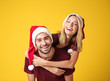 © Africa Studio - Happy young couple in Santa hats on color background. Christmas concept