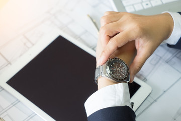 Close-up of a man 's hand with a wrist watch in office. Place on a tablet