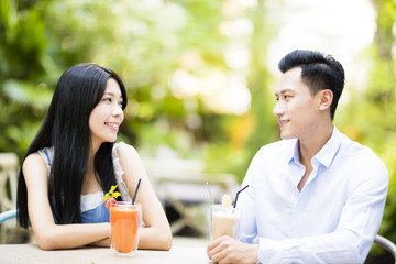 Happy young couple in restaurant enjoying drink.