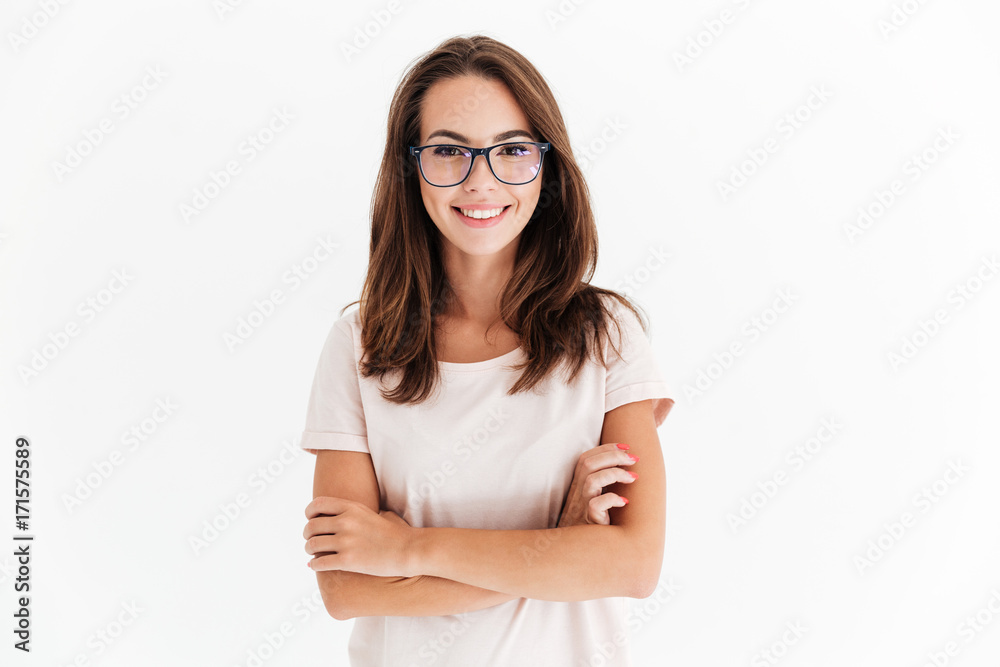 Smiling brunette woman in eyeglasses posing with crossed arms - obrazy, fototapety, plakaty 