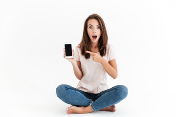 Sticker - Shocked brunette woman showing blank smartphone screen