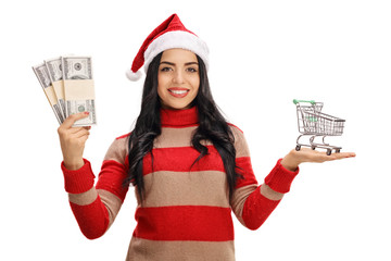 Canvas Print - Woman with christmas hat holding money bundles and shopping cart