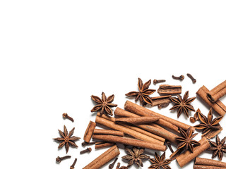 Wall Mural - Winter spices background. Cinnamon, cloves and star anise with copy space. Isolated on white with clipping path. Top view or flat lay. Winter food background concept.