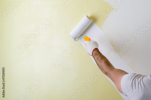Male Hand Painting Wall With Paint Roller Painting New