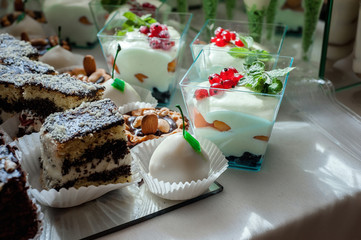 Cake, candies, marshmallows, fruits and other sweets on dessert table