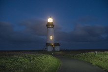 Tranquil View Of Illuminated Lighthouse Against Sky During Night