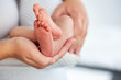 Baby feet in mother's hands. The concept of motherhood