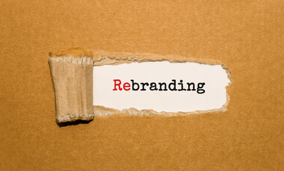 Poster - The text Rebranding appearing behind torn brown paper