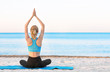 © Africa Studio - Beautiful young woman practicing yoga on sea beach