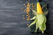 Fresh corn cob and kernels on wooden background