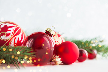 Wall Mural - red christmas ornaments on glitter holiday background with xmas tree twinkle bokeh lights. merry chr