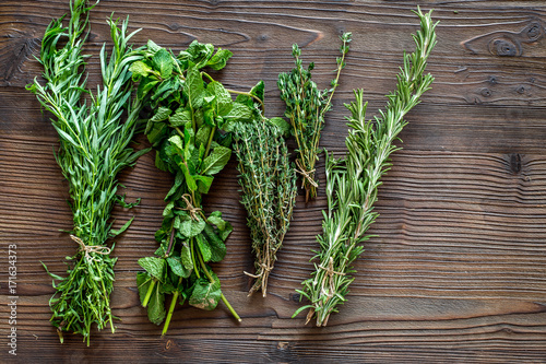 Fototapeta na drzwi i meble fresh herbs and greenery for spices and cooking on wooden desk background top view