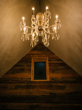 Antique Chandelier Hanging From Ceiling With Wood Walls