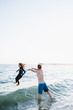 © Kristin Rogers Photography/Stocksy - Father throwing daughter for fun in the ocean