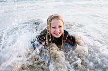 Young Girl Smiling While In Waves At Beach