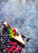 Cheesecake with berries on blue slate background.