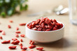 © 365mm/Stocksy - Bowl of goji berries with several scattered on table