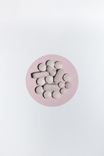 Pills On A Circular Pink Shape