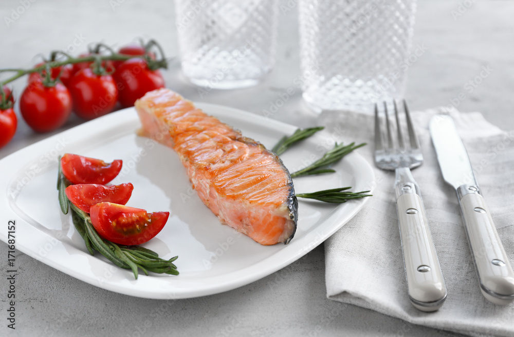 Tasty salmon with rosemary and tomato on plate