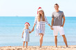 © Africa Studio - Young couple with girl on beach. Christmas celebration concept