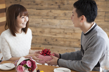 Wall Mural - Man giving present and bouquet to woman