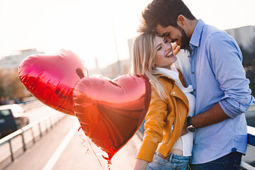 Wall Mural - Couple in love cuddling while enjoying beautiful urban sunset together