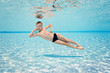 © biotin - Happy small boy swim underwater, has fun and dive in the blue transparent water of clear pool. Swimming classes and water safety education. Family vacation, weekend with kids