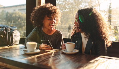 Two women having fun at a coffee shop