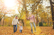 © chika_milan - Mother and father playing with son in park at autumn/ flying kite