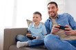 © Syda Productions - father and son playing video game at home