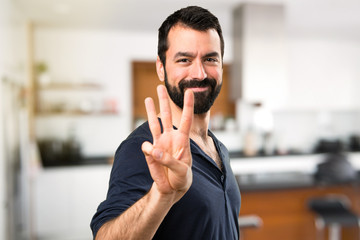 Handsome man with beard counting three inside house