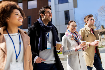 Wall Mural - people with coffee and conference badges in city