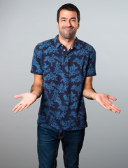 Brunette man making unimportant gesture on grey background