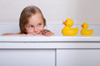 © tirlik - baby girl taking bath with foam and toys