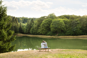 Senior couple on a walk at the lake hugging.